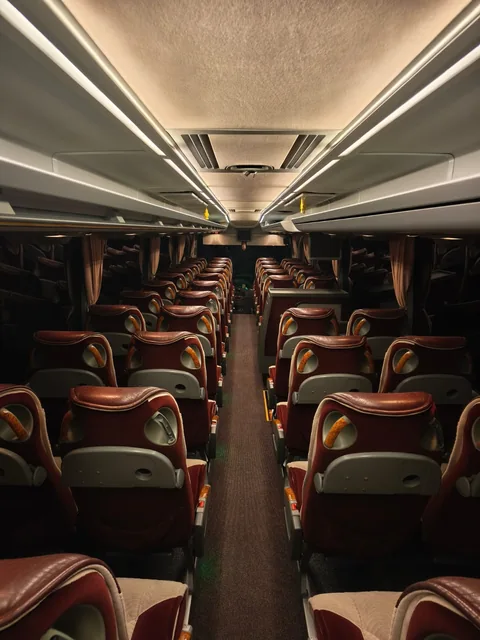 Coach aisle with burgundy and beige passenger seats