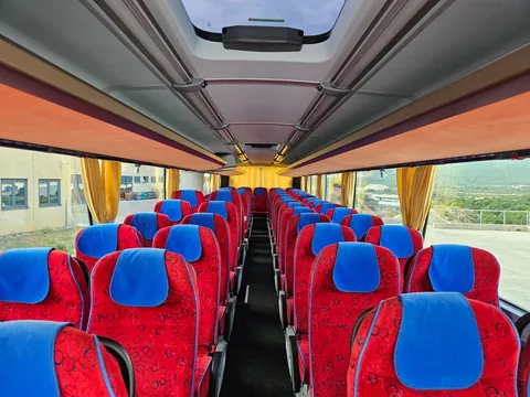 Coach cabin with red seats and blue headrests
